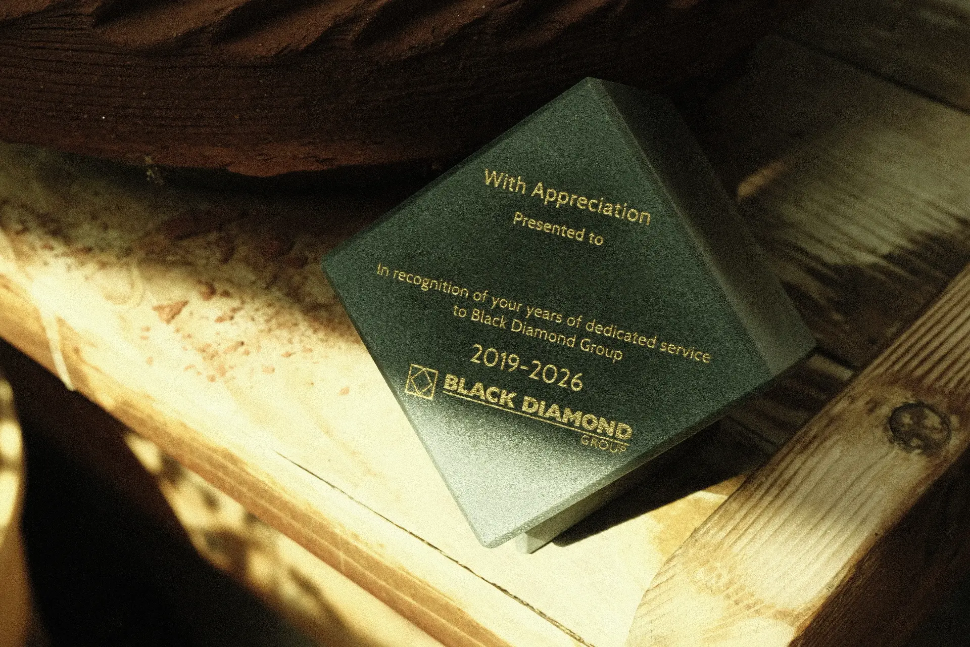 Black Diamond Group concrete retirement award on a wooden workbench